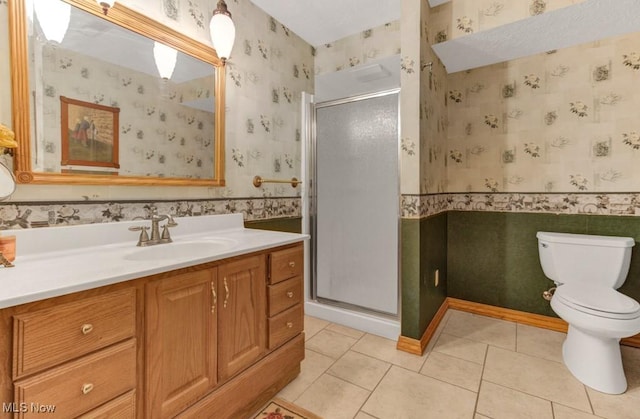 bathroom featuring vanity, tile patterned flooring, a shower with shower door, and toilet