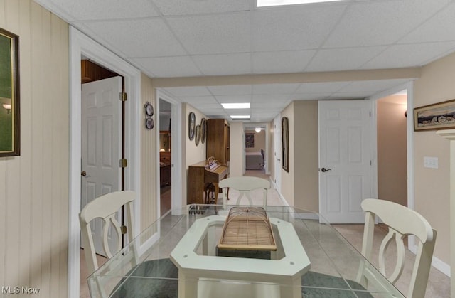 tiled dining room with a drop ceiling