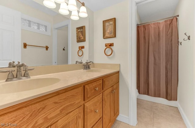 bathroom featuring tile patterned flooring, vanity, and a notable chandelier