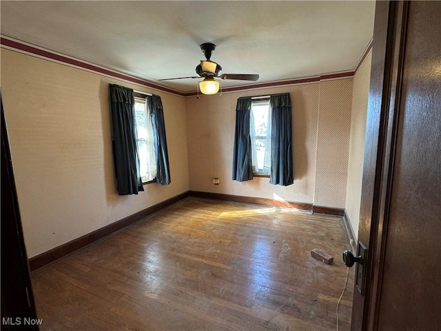 unfurnished room featuring crown molding, wood-type flooring, and ceiling fan