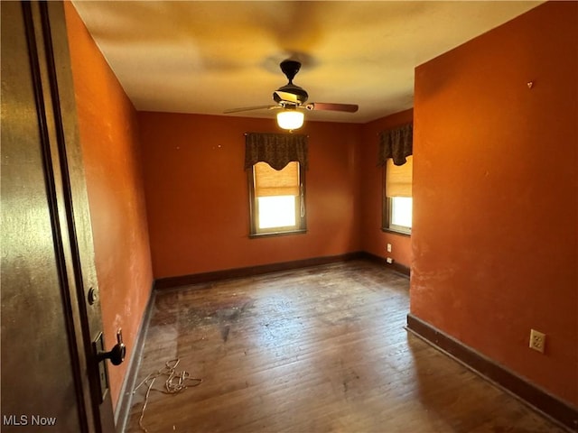 empty room featuring dark wood-type flooring and ceiling fan