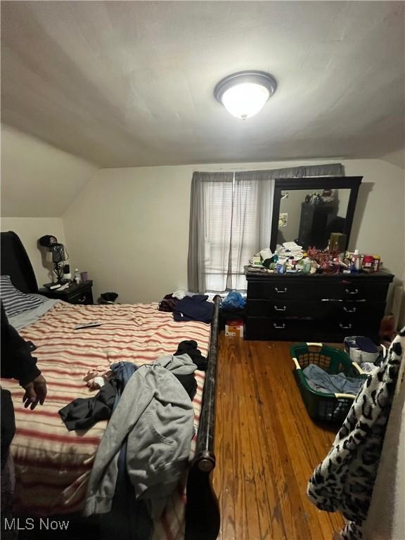 bedroom with wood-type flooring and lofted ceiling