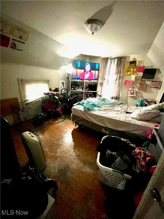 bedroom with lofted ceiling and wood-type flooring