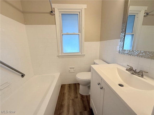 bathroom featuring vanity, hardwood / wood-style floors, tile walls, and toilet