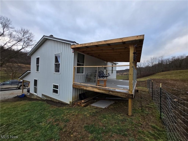 view of side of property featuring a wooden deck and a lawn