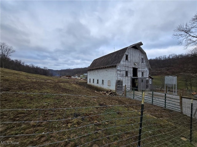 view of property exterior with an outbuilding and a rural view