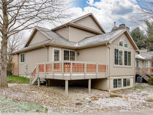 rear view of property with a wooden deck and cooling unit