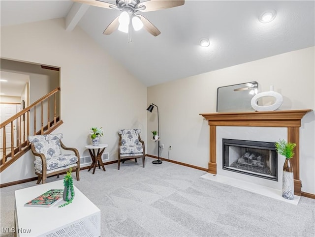 living area with ceiling fan, light carpet, and vaulted ceiling with beams