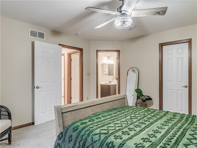 carpeted bedroom featuring ensuite bath and ceiling fan