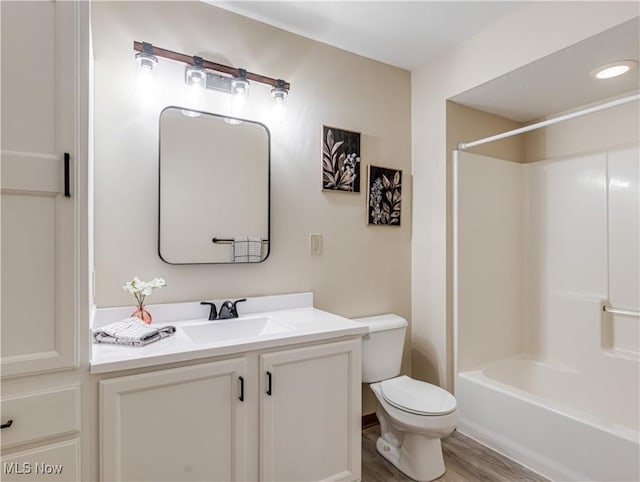 full bathroom featuring bathtub / shower combination, vanity, toilet, and hardwood / wood-style floors