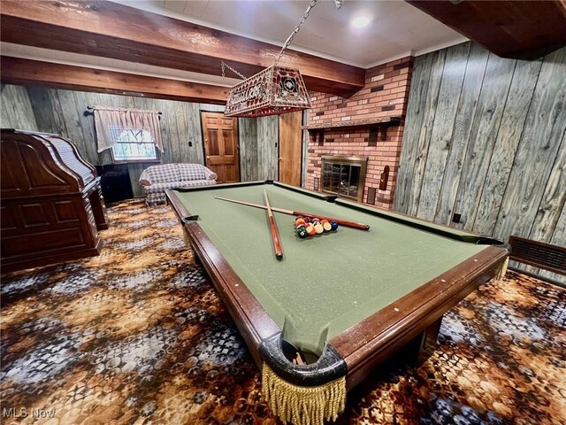 game room featuring beamed ceiling, wooden walls, and a fireplace