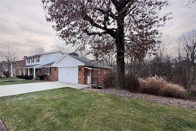 view of front of property featuring brick siding, concrete driveway, a front yard, a chimney, and an attached garage