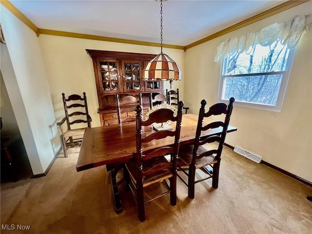 carpeted dining area with ornamental molding