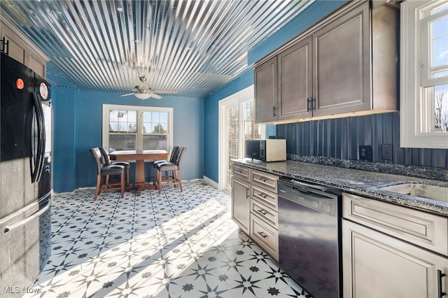 kitchen with ceiling fan, dark stone counters, and black appliances