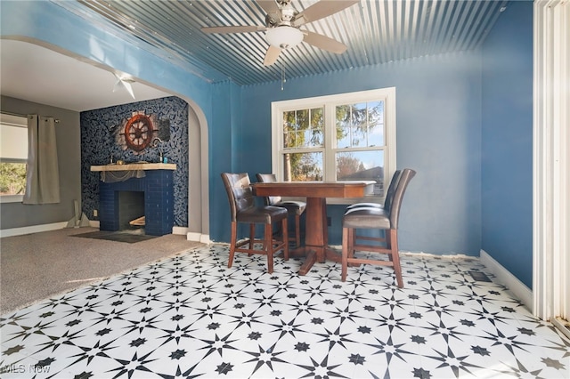 dining space featuring ceiling fan and a fireplace