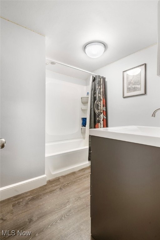 bathroom featuring wood-type flooring, vanity, and shower / bath combo with shower curtain