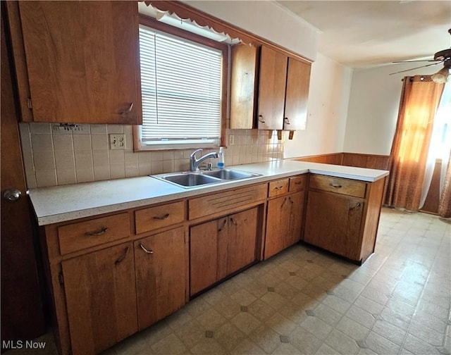 kitchen with sink, backsplash, ceiling fan, and kitchen peninsula