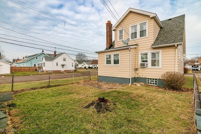 rear view of house featuring cooling unit and a lawn