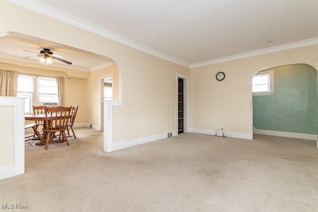 spare room with ceiling fan, ornamental molding, and light carpet