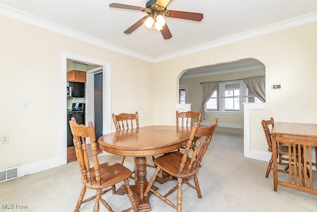 dining area featuring ceiling fan, light colored carpet, and ornamental molding