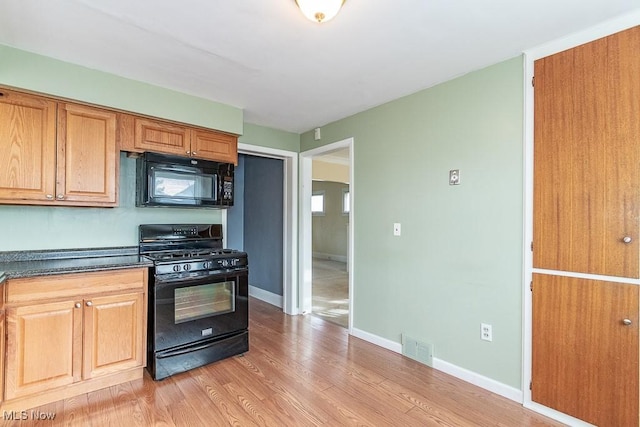 kitchen with light wood-type flooring and black appliances