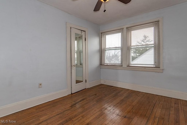 empty room featuring dark wood-type flooring and ceiling fan