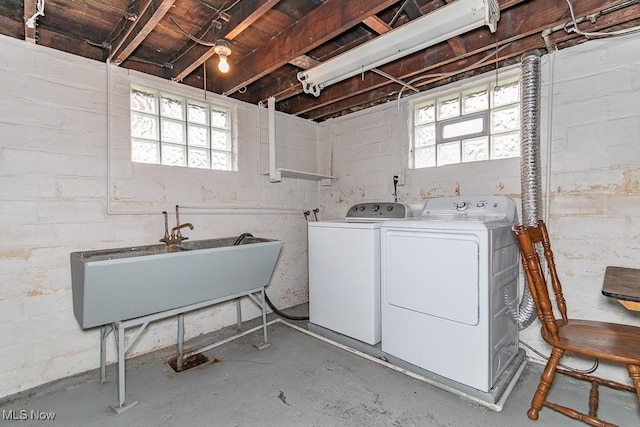 washroom with sink, a wealth of natural light, and washer and clothes dryer