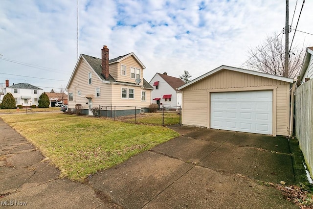 exterior space featuring a garage, an outdoor structure, and a lawn