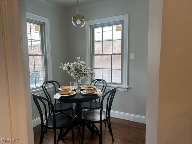 dining space with plenty of natural light, baseboards, and dark wood-type flooring