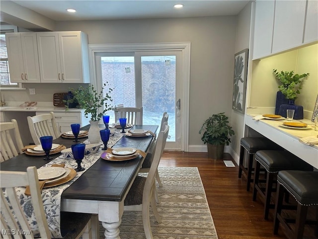 dining room featuring a healthy amount of sunlight, baseboards, dark wood-style flooring, and recessed lighting