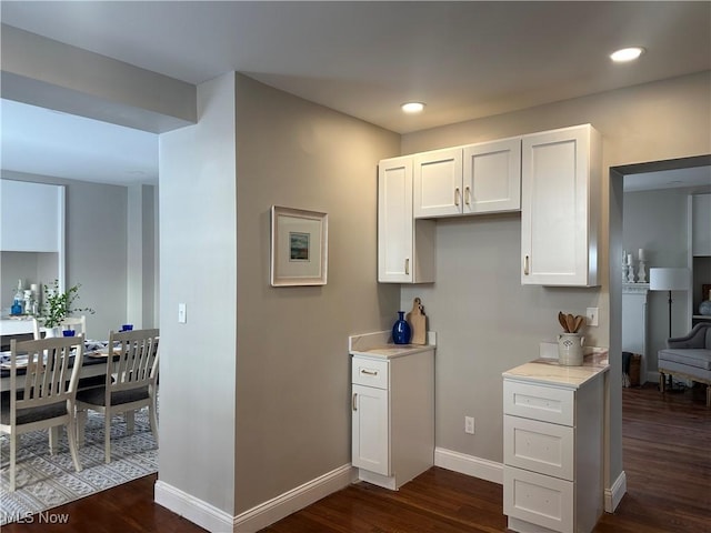 kitchen featuring baseboards, white cabinetry, light countertops, and dark wood finished floors