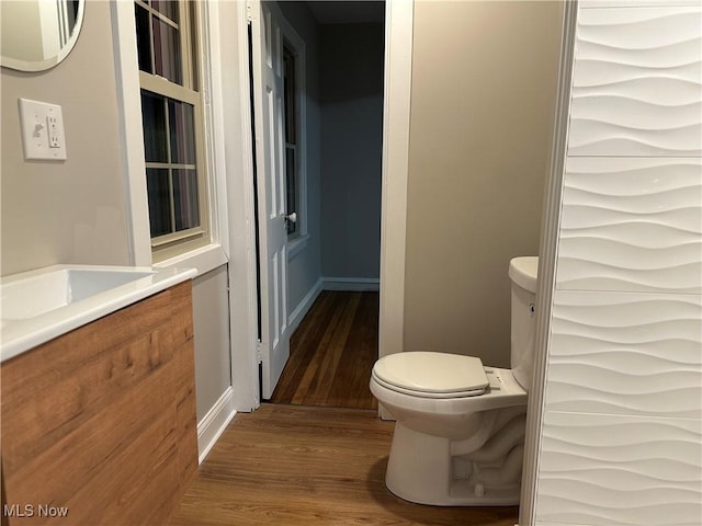 bathroom with vanity, wood finished floors, and toilet