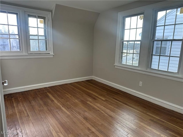 unfurnished room featuring dark wood-style floors and baseboards