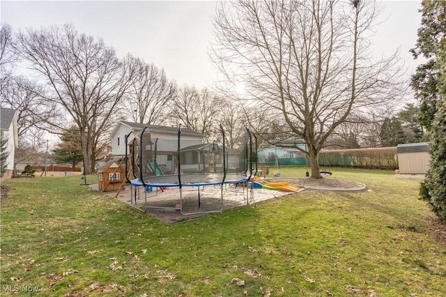 view of yard featuring a trampoline, a playground, and a shed