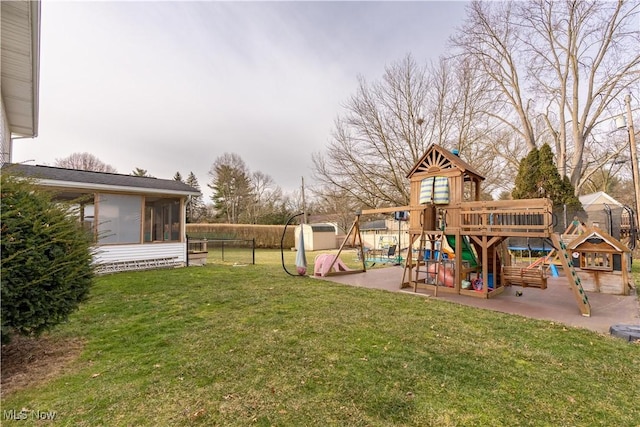 view of playground with a sunroom, a patio, and a lawn