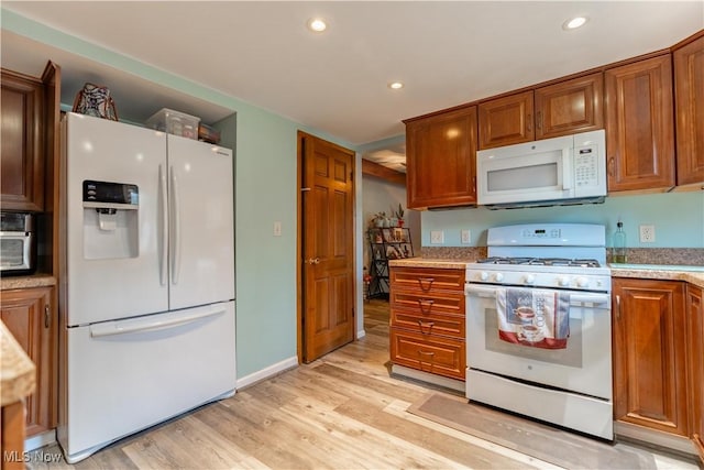 kitchen with white appliances and light wood-type flooring