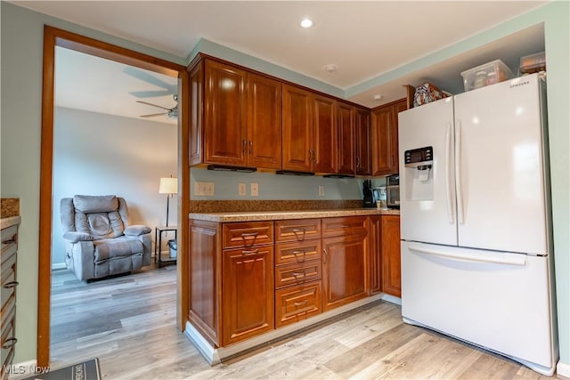 kitchen with ceiling fan, white refrigerator with ice dispenser, and light hardwood / wood-style floors