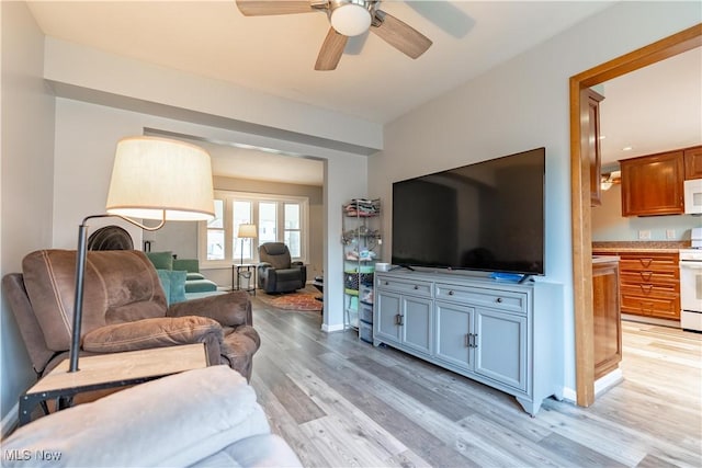 living room featuring ceiling fan and light hardwood / wood-style floors