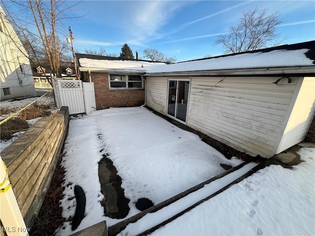 view of snow covered rear of property