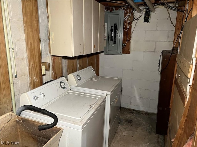 laundry room featuring separate washer and dryer, electric panel, and cabinets