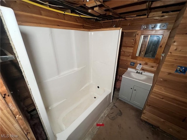 bathroom featuring vanity, concrete floors, and wood walls