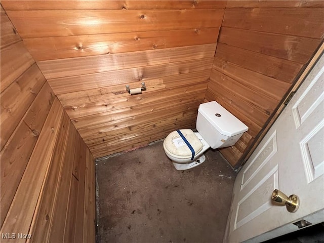 bathroom with wooden walls and toilet