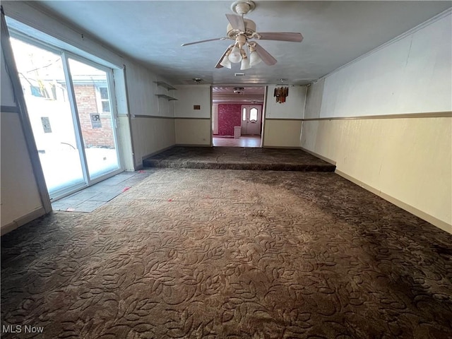 spare room featuring ceiling fan and carpet