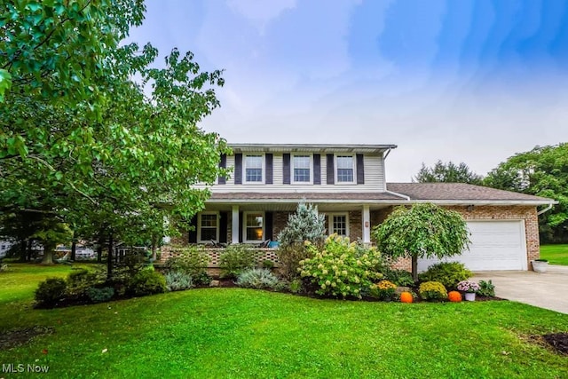 colonial home with a garage and a front lawn