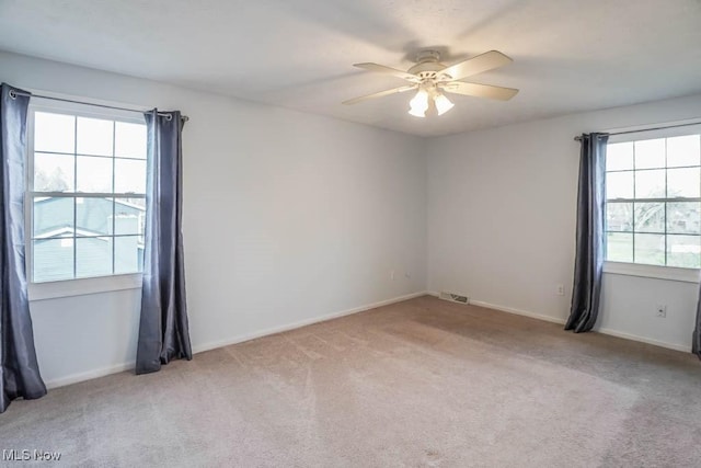 empty room featuring ceiling fan and light colored carpet