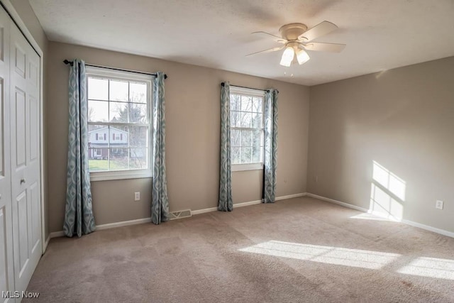 carpeted empty room featuring ceiling fan