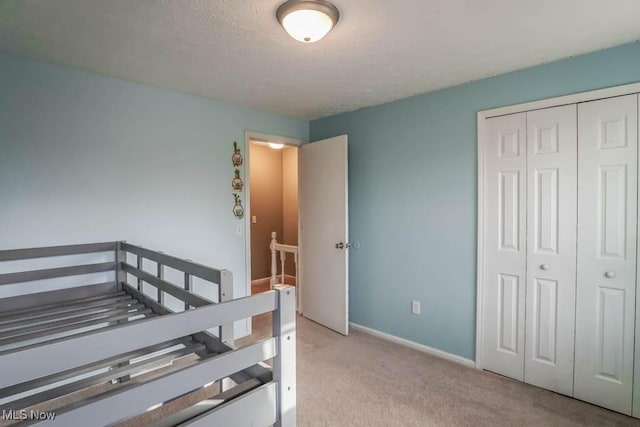 carpeted bedroom featuring a closet and a textured ceiling