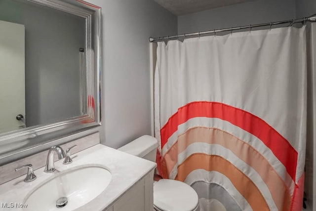 bathroom featuring vanity, toilet, and a shower with shower curtain