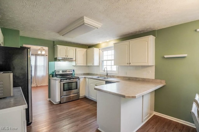 kitchen featuring white cabinetry, sink, dark hardwood / wood-style flooring, kitchen peninsula, and stainless steel appliances