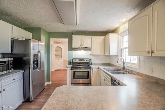 kitchen with white cabinetry, stainless steel appliances, dark hardwood / wood-style floors, and sink